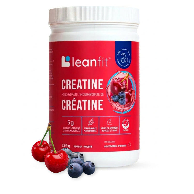 A white plastic tub of leanfit Creatine Monohydrate with a red label, shown on a white background with fresh cherries and blueberries in the foreground.